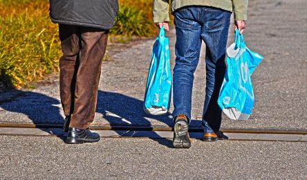 Men walking with plastic carrier bags.