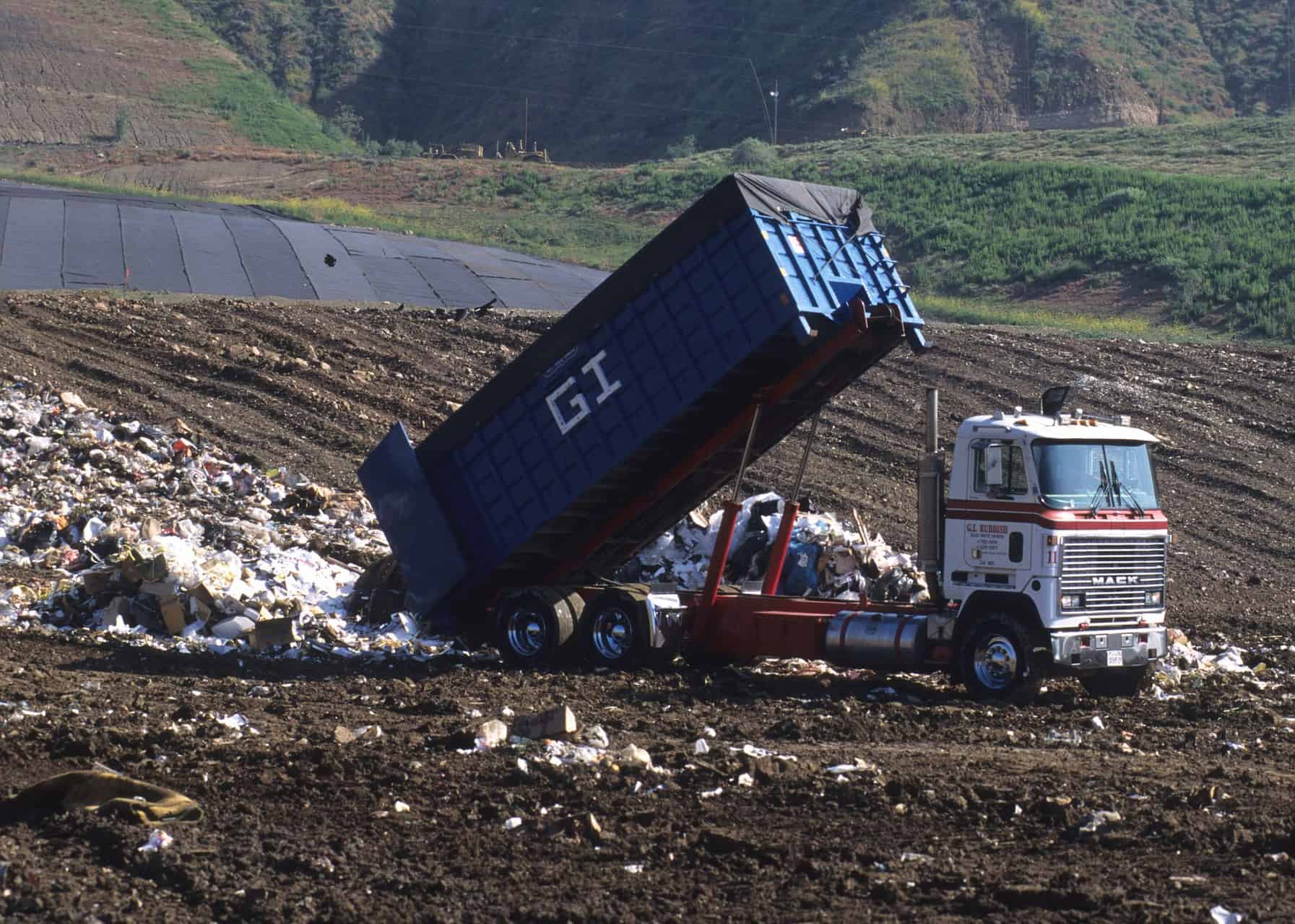 Garbage truck emptying rubbish outside tip