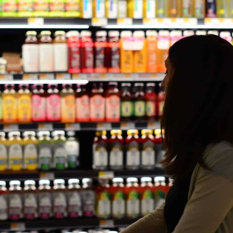 A women looking at products on a supermarket aisle.