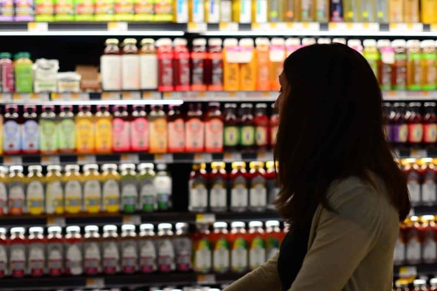 A women looking at products on a supermarket aisle.